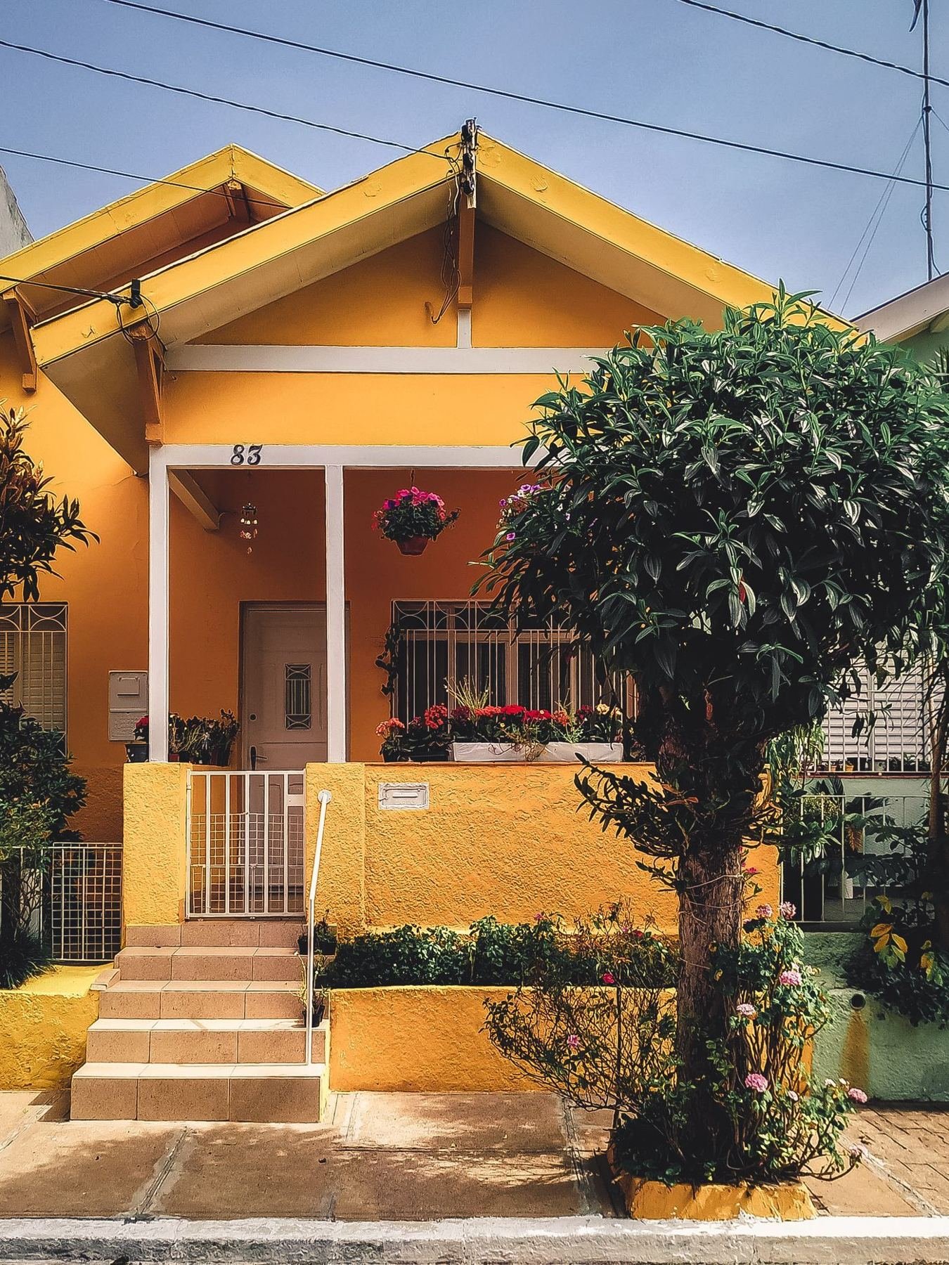 Fachada de una casa amarilla con jardín al frente