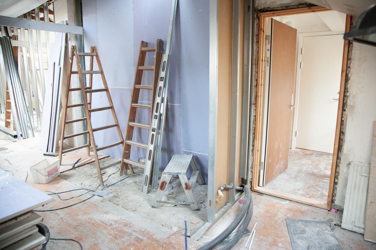 Interior de una vivienda en obra con escaleras y materiales
